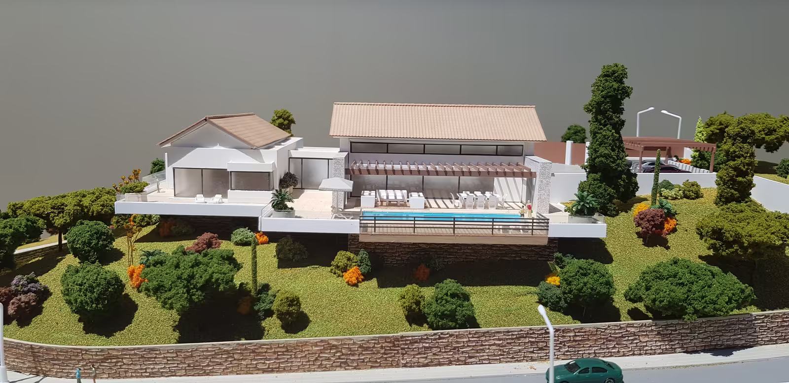 La Montua model: the villa on the hillside, with pitched roofs, terraces and the pool