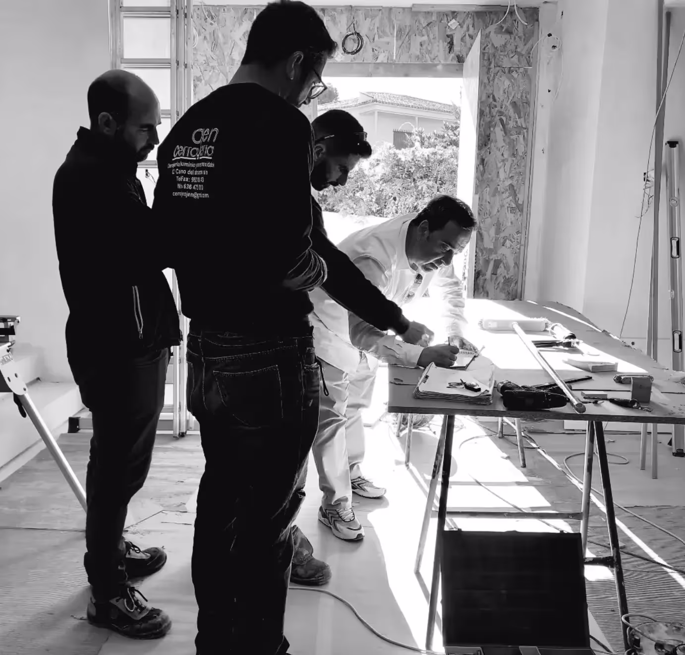 Francisco Martínez Galván on site, going over notes with the trades at a worktable