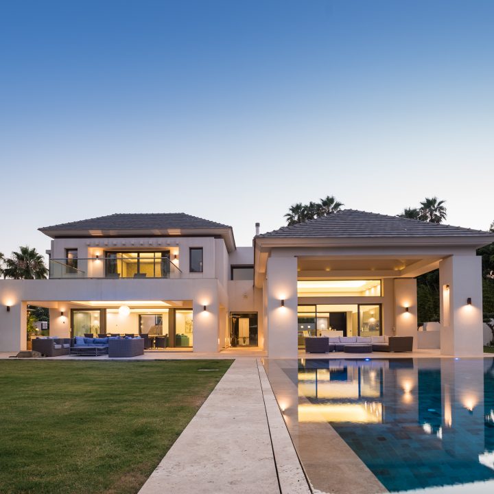 Villa Guadalmina 27 at dusk, lawn, linear pool and covered terrace